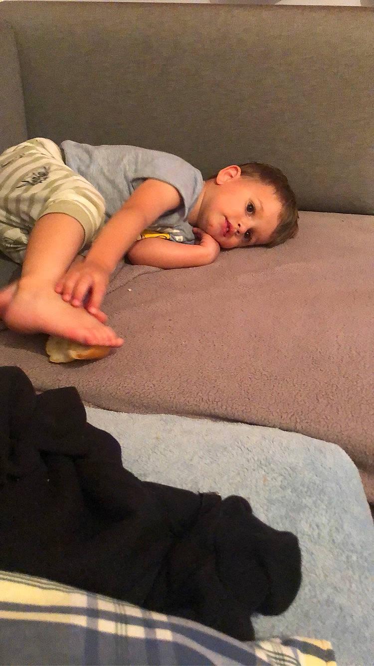 Lyam participe au concours pour gagner de l'argent avec cette photo : barefoot, bedding, bedtime, carpet, child, comfort, floor, flooring, foot, fur, hardwood, human_leg, joint, knee, linens, nap, person, sitting, thigh, toddler