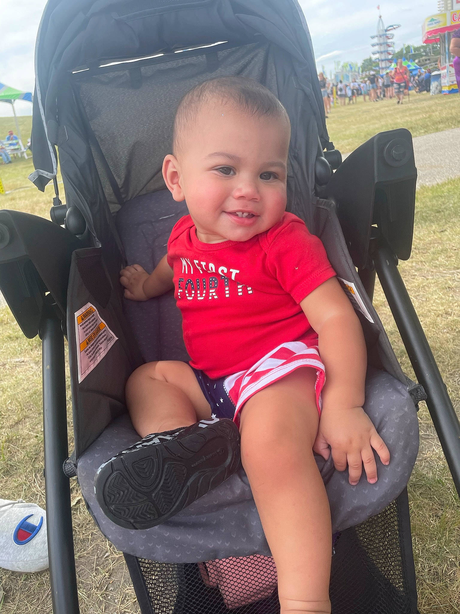 Demitris is registered to the contest to win money with this photo: baby_toddler_clothing, black, chair, comfort, cool, finger, fun, grass, hand, happy, human_body, joy, lap, leg, leisure, person, product, skin, smile, standing