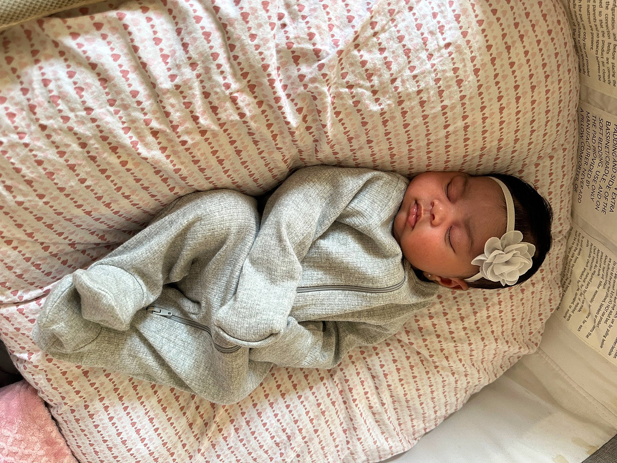 Oaklinn is registered to the contest to win money with this photo: arm, baby, baby_products, baby_sleeping, baby_toddler_clothing, bedding, beige, child, comfort, hand, headgear, headwear, human_body, infant_bed, leg, linens, person, room, textile, toddler