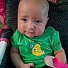 baby, child, clothing, cute, face, feeding, food, green_shirt, high_chair, indoor, infant, messy_face, minnie_mouse, pear_cartoon, person, polka_dot, seat, smile, spoon, toy