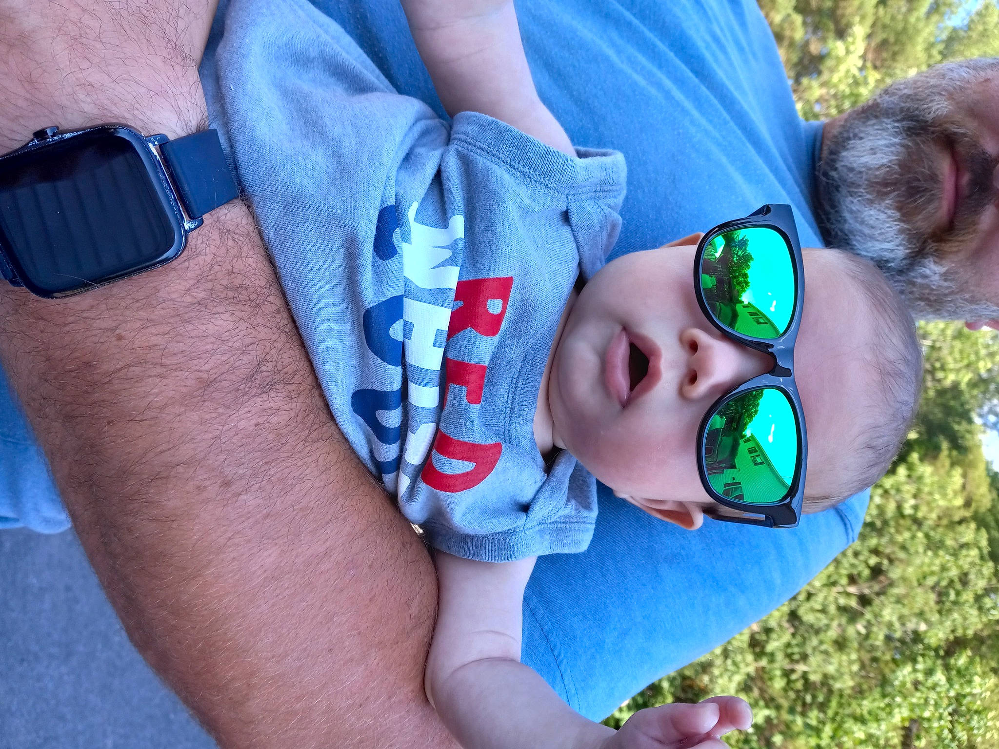 Edison is registered to the contest to win money with this photo: arm, baby_toddler_clothing, blue, eyewear, face, finger, gesture, glasses, goggles, hand, happy, leg, mouth, organ, person, plant, product, skin, sunglasses, tree