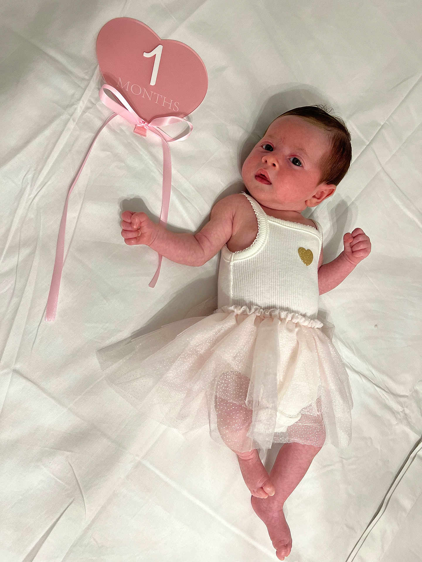 Leewane participe au concours pour gagner de l'argent avec cette photo : baby, infant, newborn, tutu, white_clothing, pink_sign, heart_shape, lying_down, bed_sheet, curious_expression, small_hands, small_feet, cute, soft_lighting, portrait, one_month, ribbon, pink_and_white, skin, person