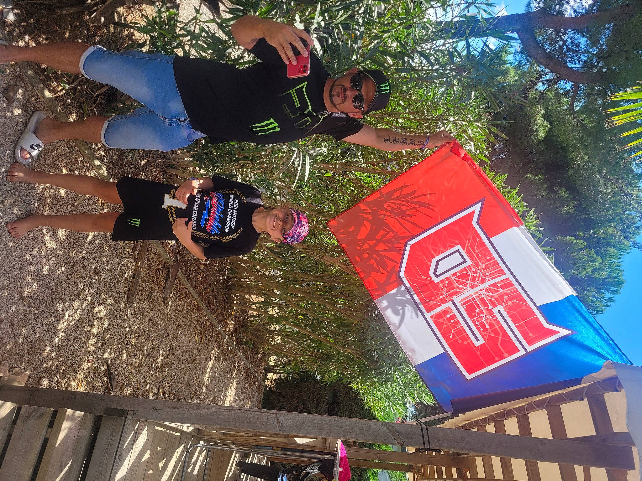 Inna participe au concours pour gagner de l'argent avec cette photo : advertising, banner, font, fun, grass, headwear, joy, leisure, logo, person, plant, recreation, sign, signage, t_shirt, travel, tree, vacation, world