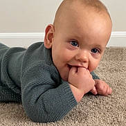 Isaiah joined the competition — help win amazing prizes! baby, blue_eyes, carpet, child, cozy, cute, face, fingers, floor, green, hand, indoor, infant, knitted, lying_down, portrait, skin, smile, sweater, wall