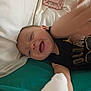 Jordan joined the competition — help win amazing prizes! baby, bed, black_shirt, child, clothing, cute, face, happy, head, indoors, infant, joy, lying_down, mouth_open, person, pillow, reaching, smiling, teething_toy, toy