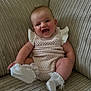 baby, infant, smile, laughing, couch, knitted_outfit, socks, frills, happy, cute, indoor, child, person, seated, texture, beige, cozy, portrait, young, comfortable