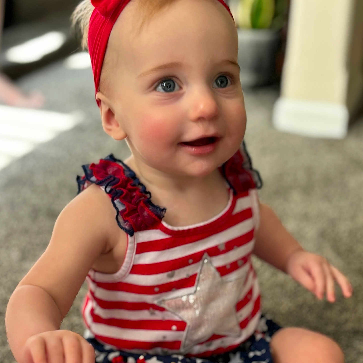 Mila is registered to the contest to win money with this photo: accessories, baby, bodypart, clothing, dress, face, finger, hand, happy, head, headband, jewelry, necklace, person, photography, portrait, shorts, sitting, smile, t_shirt