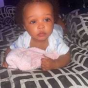 Zaiden joined the competition — help win amazing prizes! baby, infant, bed, blanket, patterned_bedspread, curly_hair, indoor, soft_toy, child, person, headboard, young, cute, expression, clothing, sleepwear, toddler, face, hands, resting