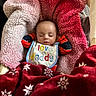 Daniel is registered to the contest to win money with this photo: baby, bib, blanket, closed_eyes, clothing, comfort, cozy, cute, face, indoor, infant, pattern, person, pink_blanket, red_blanket, resting, sleeping, soft_texture, toddler, warm