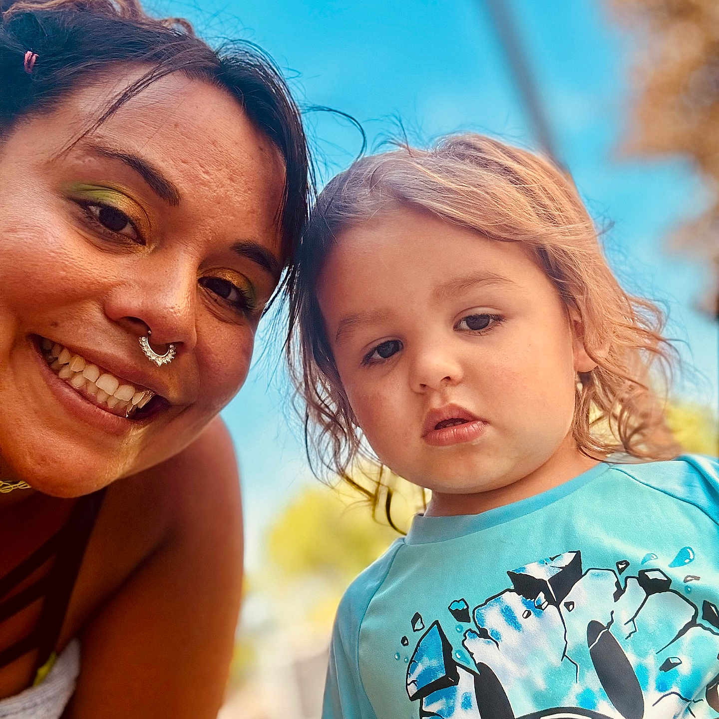 Joseph is registered to the contest to win money with this photo: adult, child, smile, face, outdoor, blue_sky, toddler, person, portrait, happy, casual_clothing, makeup, short_hair, nature, daylight, closeup, fun, family, nose_ring, graphic_tshirt