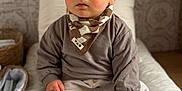 Gaspard a rejoint le concours — aidez-le/la à gagner de superbes lots ! baby, infant, child, sitting, bandana, socks, sweater, pants, pillow, changing_pad, nursery, basket, curious_gaze, big_eyes, portrait, indoor, soft_light, neutral_colors, wood_floor, cute