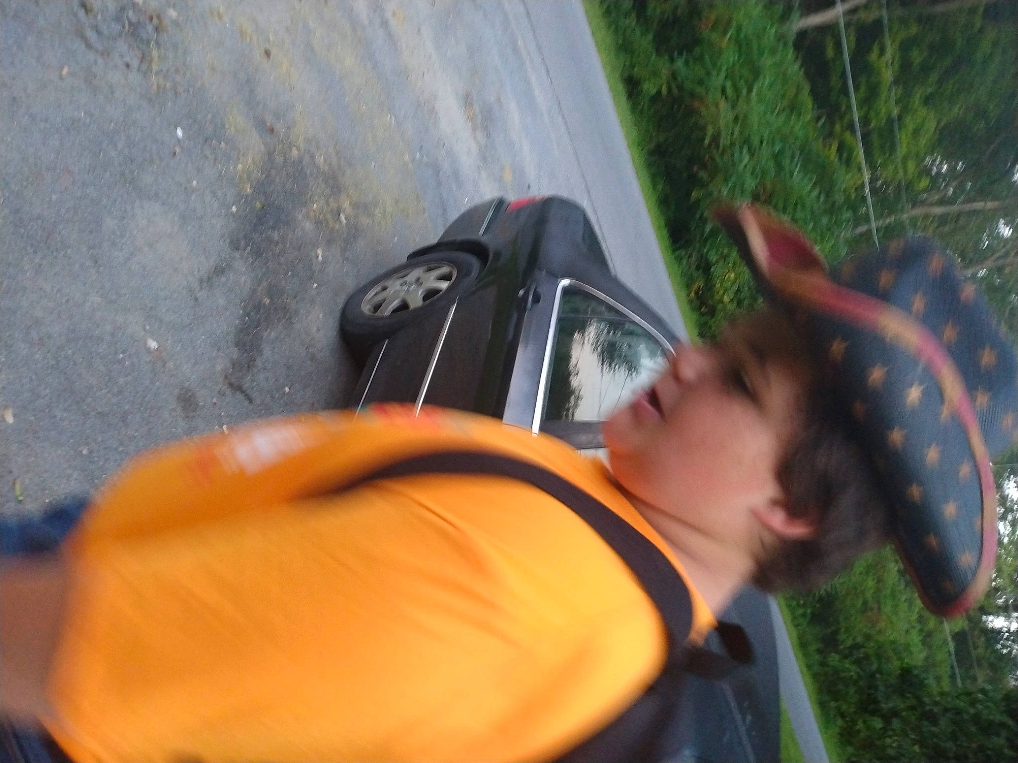 Elijah is registered to the contest to win money with this photo: asphalt, automotive_exterior, automotive_lighting, backpack, eyewear, fun, grass, happy, human_leg, leisure, luggage_and_bags, person, personal_protective_equipment, plant, recreation, sunglasses, t_shirt, travel, tree, vehicle_door