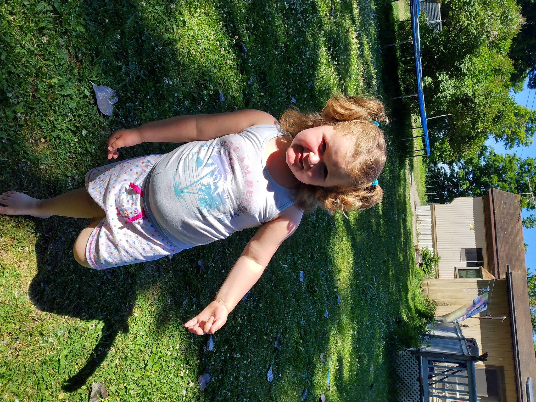 Alyvia is registered to the contest to win money with this photo: barefoot, fun, grass, grass_family, happy, human_leg, knee, lawn, leisure, people_in_nature, person, plant, play, recreation, sky, smile, t_shirt, thigh, toddler, tree