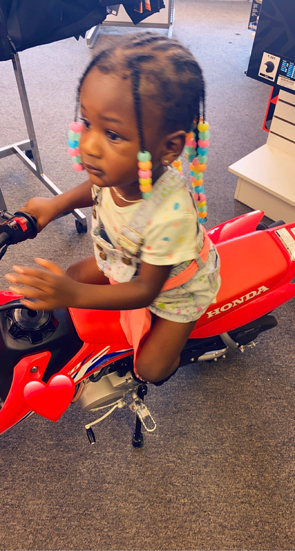 Niyah is registered to the contest to win money with this photo: child, flooring, fun, hairstyle, hand, happy, head, human_leg, human_settlement, leisure, person, play, recreation, sandal, shorts, sitting, standing, t_shirt, tire, toddler