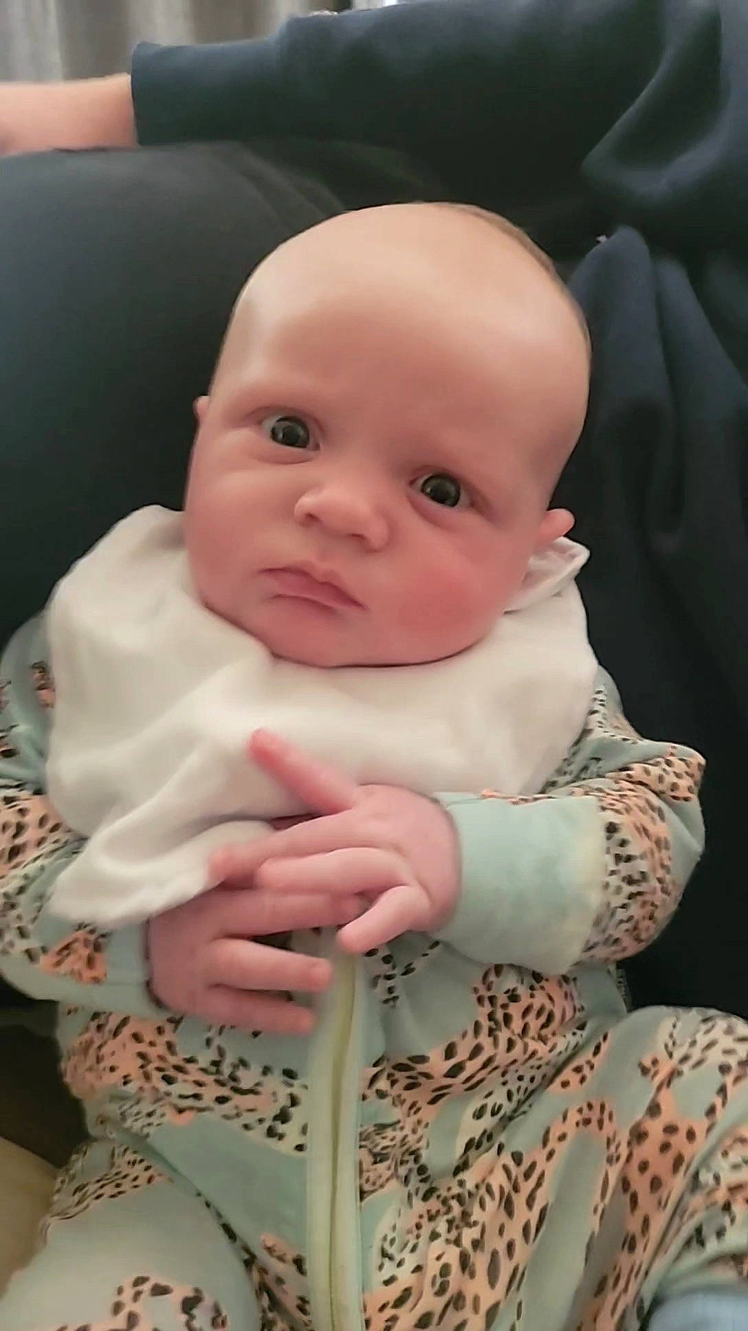 Charlie is registered to the contest to win money with this photo: baby, baby_products, baby_toddler_clothing, cheek, chin, collar, comfort, eye, human_body, iris, linens, lip, nail, person, pink, product, sitting, skin, sleeve, textile