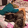 Aïko a rejoint le concours — aidez-le/la à gagner de superbes lots ! dog, person, bed, bedroom, sleeping, lying_down, pet, human, short_hair, brown_dog, large_dog, floral_bedding, pillow, indoor, home, relaxed, cuddling, funny, portrait, photography