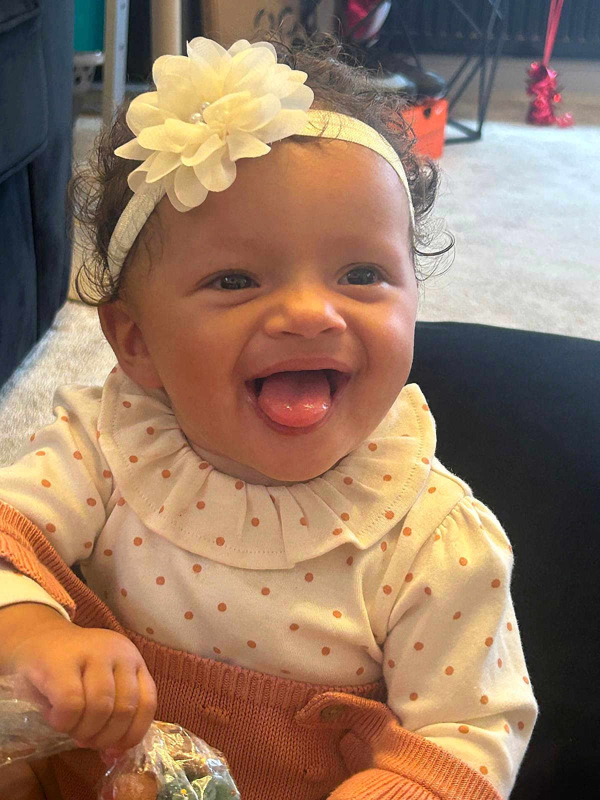 Ocean-Ray joined the competition — help win amazing prizes! baby, child, smiling, tongue_out, headband, flower, polka_dot, ruffled_collar, knitwear, hand, plastic_bag, treats, curly_hair, indoor, carpet, furniture, happy, cute, portrait, person