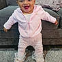 Ocean-Ray is registered to the contest to win money with this photo: baby, child, smiling, pink_outfit, headband, white_bow, standing, rug, gray_couch, blanket, happy, indoor, footwear, cute, person, infant, portrait, home, cozy, fashion