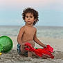 Christopher is registered to the contest to win money with this photo: child, toddler, beach, sand, sand_toys, bucket, curly_hair, ocean, sky, sunset, playing, summer, bare_chest, outdoor, vacation, seaside, toy, nature, relaxation, daytime