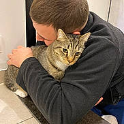 Tétard participe au concours pour gagner de l'argent avec cette photo : affection, animal, black_fleece, casual, cat, close_up, comfort, cozy, crouching, domestic, feline, floor, hug, human, indoor, person, pet, tabby_cat, tile, warmth