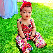 Mirha joined the competition — help win amazing prizes! baby, child, grass, outdoor, colorful_clothing, headband, sitting, curious, playful, patterned_outfit, barefoot, bracelets, sunlight, greenery, young_child, portrait, cute, casual, daylight, relaxed