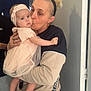Lyla a rejoint le concours — aidez-le/la à gagner de superbes lots ! adult, affection, baby, casual_clothing, child, curious, door, family, handbag, headband, holding, indoor, jeans, kiss, light_skin, love, person, pink_dress, portrait, woman