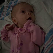 Olivia joined the competition — help win amazing prizes! baby, infant, pink_clothing, flamingo_pattern, blanket, bedding, striped_blanket, lying_down, hand_near_mouth, curious_expression, indoors, child, newborn, soft_lighting, portrait, sleepwear, cute, young_child, person, cozy