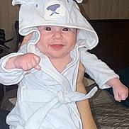 Alex joined the competition — help win amazing prizes! baby, child, hooded_robe, smiling, indoor, person, cute, infant, fist, face, clothing, bedroom, blanket, hand, happy, young, apparel, portrait, sleeves, headwear