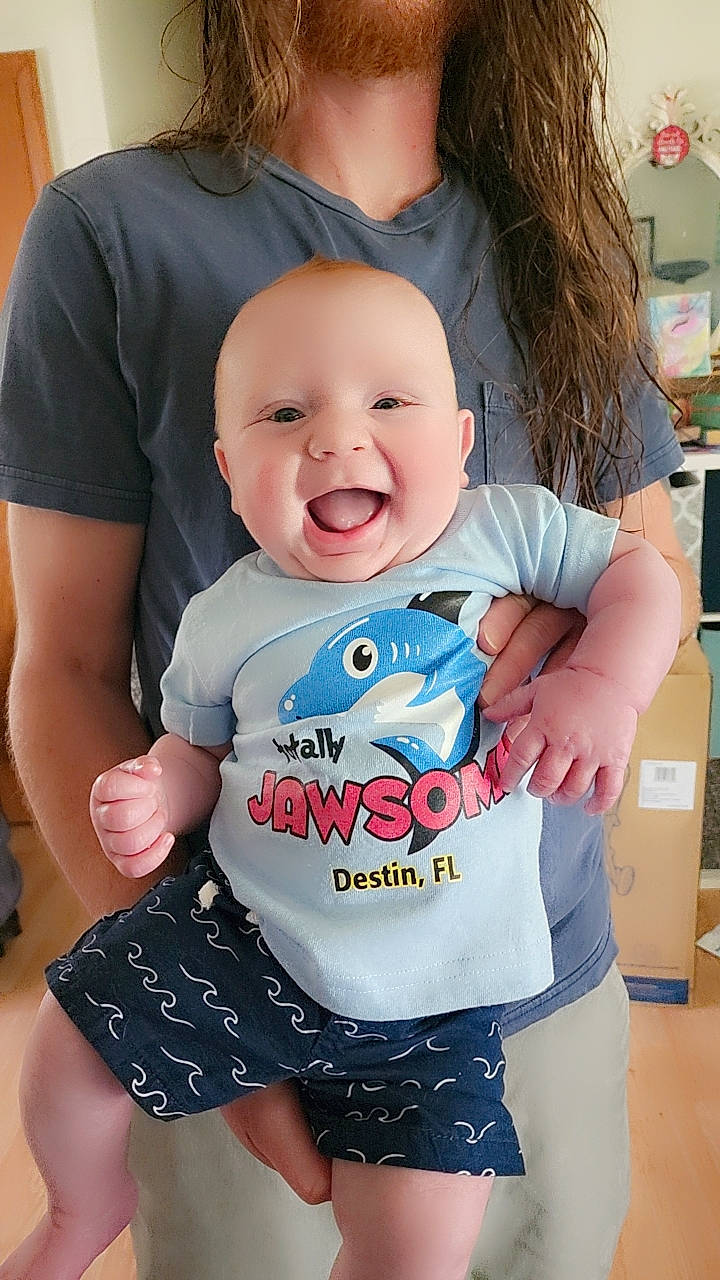 Rome is registered to the contest to win money with this photo: baby_toddler_clothing, cheek, cool, facial_expression, finger, gesture, hairstyle, happy, human_body, joint, neck, person, pink, product, shoulder, skin, sleeve, smile, standing, t_shirt