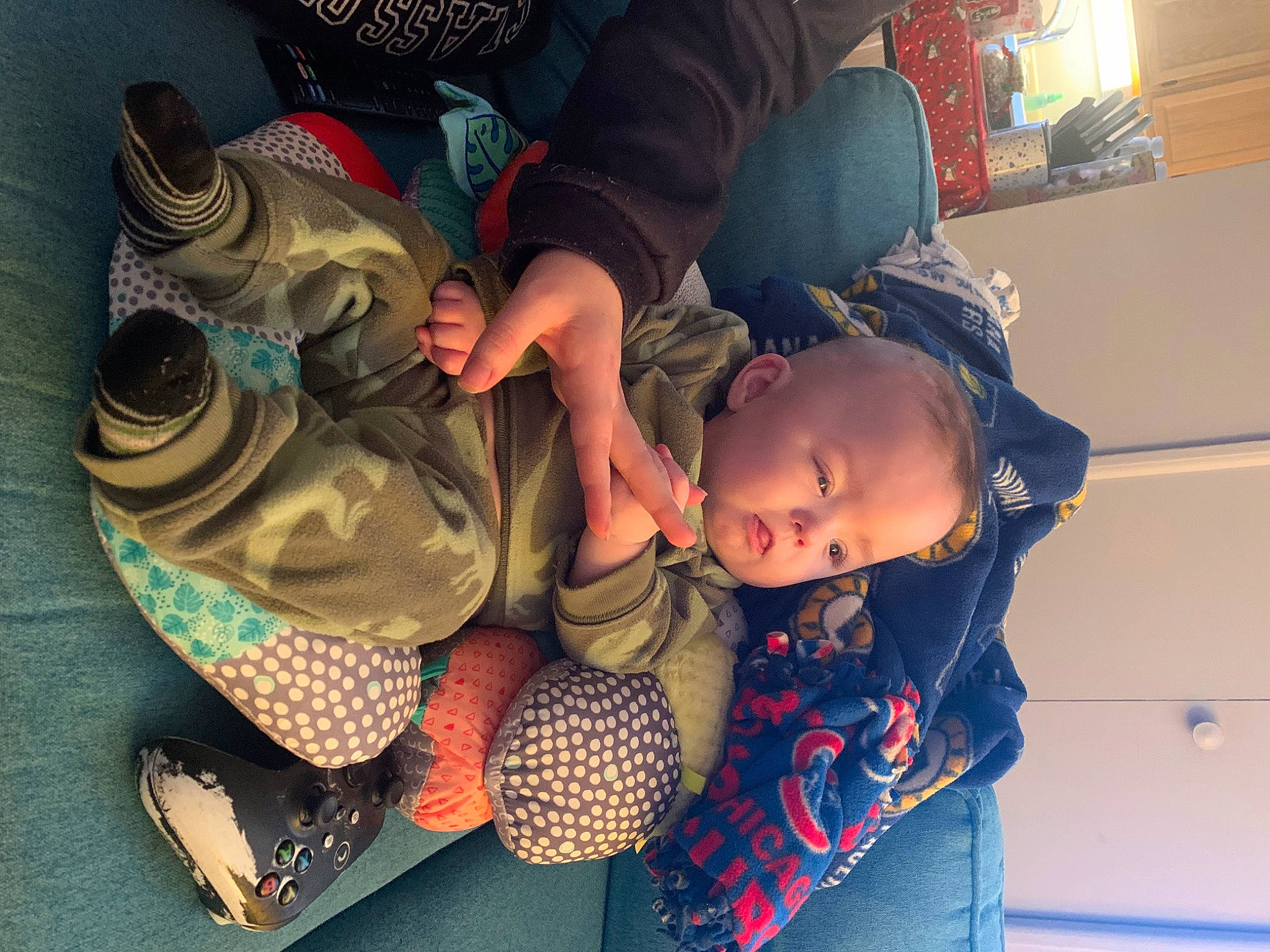 Greyson is registered to the contest to win money with this photo: baby, baby_products, child, comfort, fun, happy, lap, leisure, luggage_and_bags, mouth, pattern, person, personal_protective_equipment, play, room, sitting, thigh, toddler