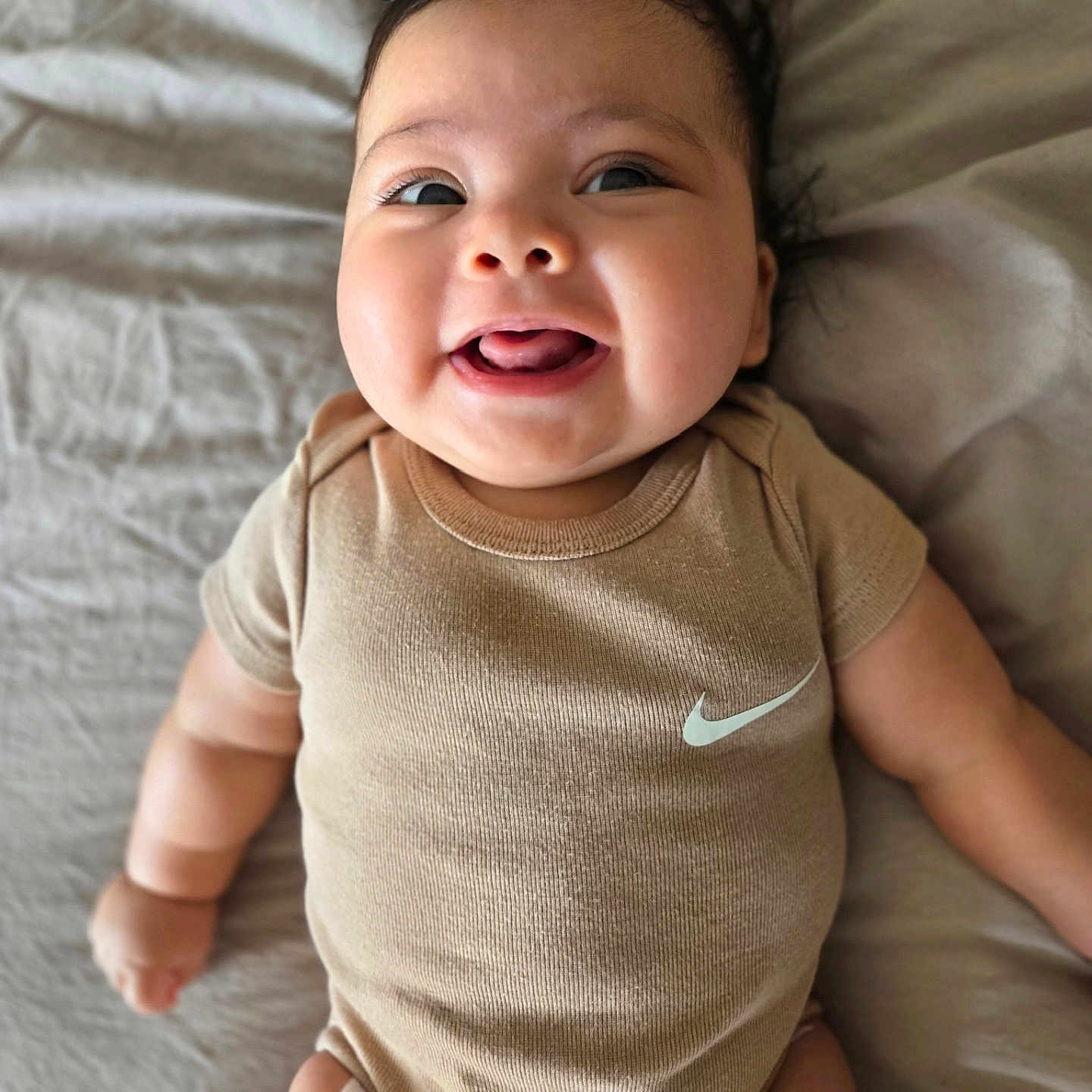 Isla Calypso is registered to the contest to win money with this photo: accessories, baby, babylaughing, bodypart, clothing, cushion, face, happy, head, homedecor, laughing, mouth, newborn, person, photography, portrait, sleeve, smile, t_shirt, teeth