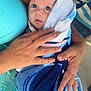 Oakley is registered to the contest to win money with this photo: baby, towel, wrapped, hands, adult, skin, blue, pattern, closeup, face, eyes, holding, comfort, warmth, outdoor, person, portrait, newborn, infant, care
