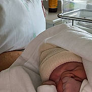 Nëylia participe au concours pour gagner de l'argent avec cette photo : newborn, baby, blanket, hat, sleeping, hospital, bassinet, pillow, fan, white, clothing, infant, bed, cozy, cute, peaceful, wrapped, person, indoors, resting