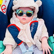 Chloé a rejoint le concours — aidez-le/la à gagner de superbes lots ! accessory, baby, car_seat, child, clothing, cozy, cute, face, fashion, hands, hoodie, indoor, infant, plush, portrait, reflection, safety, seatbelt, sunglasses, wearing
