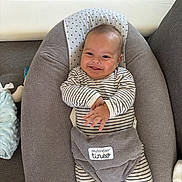 Tiago participe au concours pour gagner de l'argent avec cette photo : baby, smile, infant, striped_clothing, cushion, baby_seat, indoor, happy, child, onesie, relaxing, cute, person, soft_texture, head, face, small_hands, comfort, seat, baby_accessory