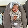 baby, smile, infant, striped_clothing, cushion, baby_seat, indoor, happy, child, onesie, relaxing, cute, person, soft_texture, head, face, small_hands, comfort, seat, baby_accessory