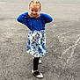 child, girl, pose, blue_clothing, floral_skirt, black_tights, shoes, asphalt, sidewalk, car, chalk_markings, outdoor, playground, confident, smiling, young, fashion, hair_buns, earrings, street