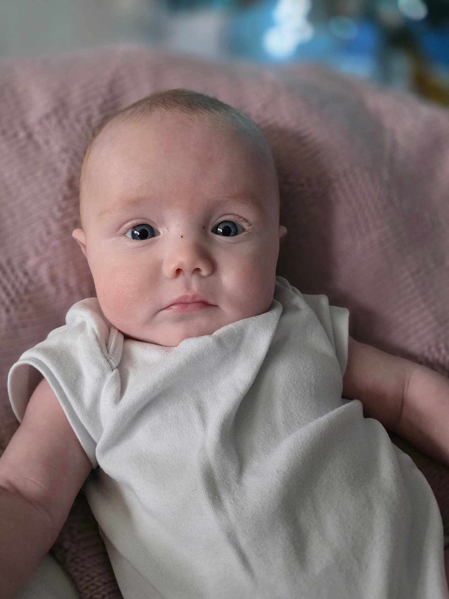 Arien joined the competition — help win amazing prizes! baby, infant, face, eyes, expression, clothing, blanket, texture, soft, comfort, skin, head, portrait, cute, young, person, indoors, laying, white, sleepwear