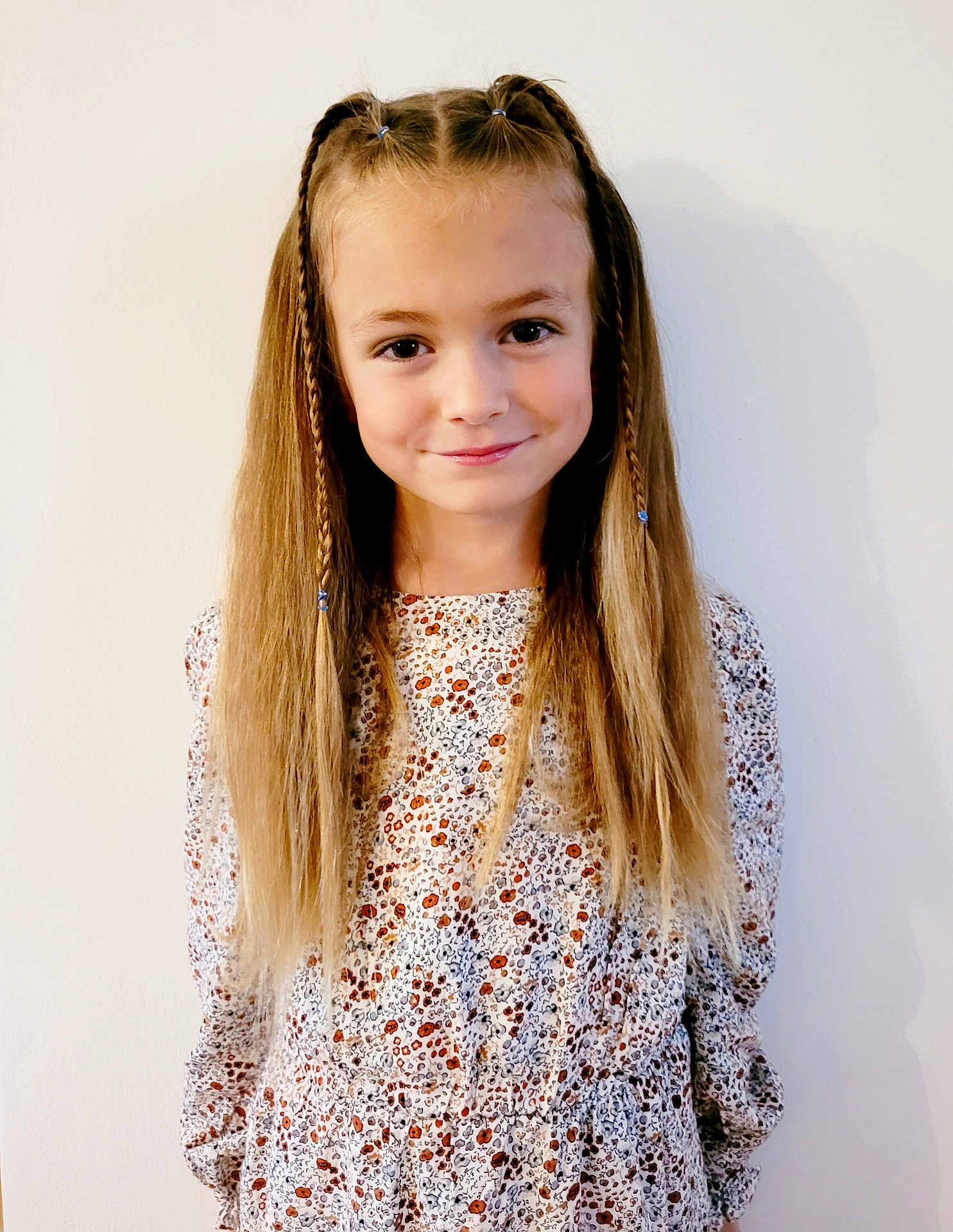 Iris participe au concours pour gagner de l'argent avec cette photo : child, girl, smile, blonde_hair, braids, long_hair, floral_dress, patterned_clothing, standing, portrait, white_background, happy, cute, fashion, youth, innocence, person, casual, indoor, light