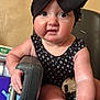 Scarlet is registered to the contest to win money with this photo: baby, child, high_chair, black_bow, headwrap, onesie, drool, curious, chubby_cheeks, arm, hand, face, indoor, furniture, seat, person, skin, expression, closeup, infant