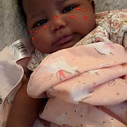 Torii is registered to the contest to win money with this photo: baby, infant, blanket, pink, unicorn_pattern, face, cheeks, heart_stickers, cozy, lying_down, soft_texture, cute, child, portrait, indoors, closeup, sleepwear, newborn, resting, person