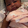 baby, infant, blanket, pink, unicorn_pattern, face, cheeks, heart_stickers, cozy, lying_down, soft_texture, cute, child, portrait, indoors, closeup, sleepwear, newborn, resting, person