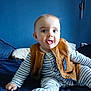 Gabriel participe au concours pour gagner de l'argent avec cette photo : baby, child, striped_pajamas, brown_vest, bed, blue_wall, playful, tongue_out, sitting, indoor, cute, person, infant, smiling, soft_lighting, home, portrait, cozy, happy, young_child