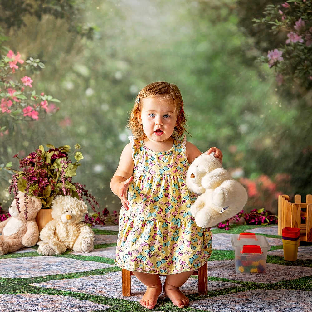 Potty For Kids joined the competition — help win amazing prizes! child, toddler, girl, portrait, outdoor, garden, flowers, teddy_bear, stuffed_animals, dress, butterfly_pattern, standing, smiling, barefoot, toys, toy_fence, play_area, colorful, storybook, photography