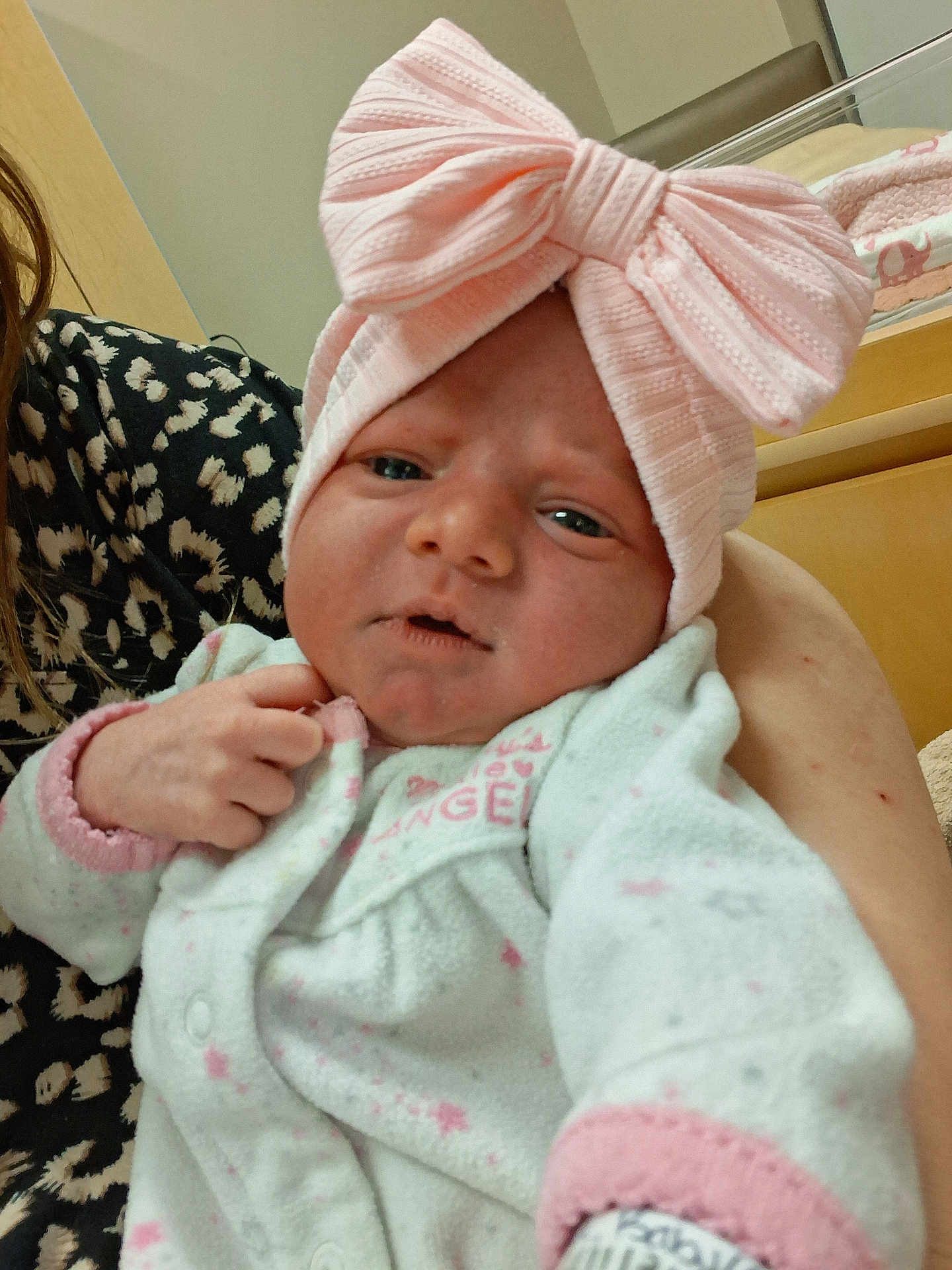 Sophia Valentina joined the competition — help win amazing prizes! baby, infant, headband, pink_bow, onesie, hand, person, indoor, crib, blanket, leopard_print, curious, cute, child, newborn, clothing, portrait, soft_lighting, care, family