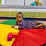 Isaiah joined the competition — help win amazing prizes! baby, child, play_mat, purple_outfit, pacifier, toy_blocks, stuffed_toys, couch, indoor, floor, colorful, patterned_clothing, infant, laying_down, soft_toys, room, carpet, cute, young_child, playtime