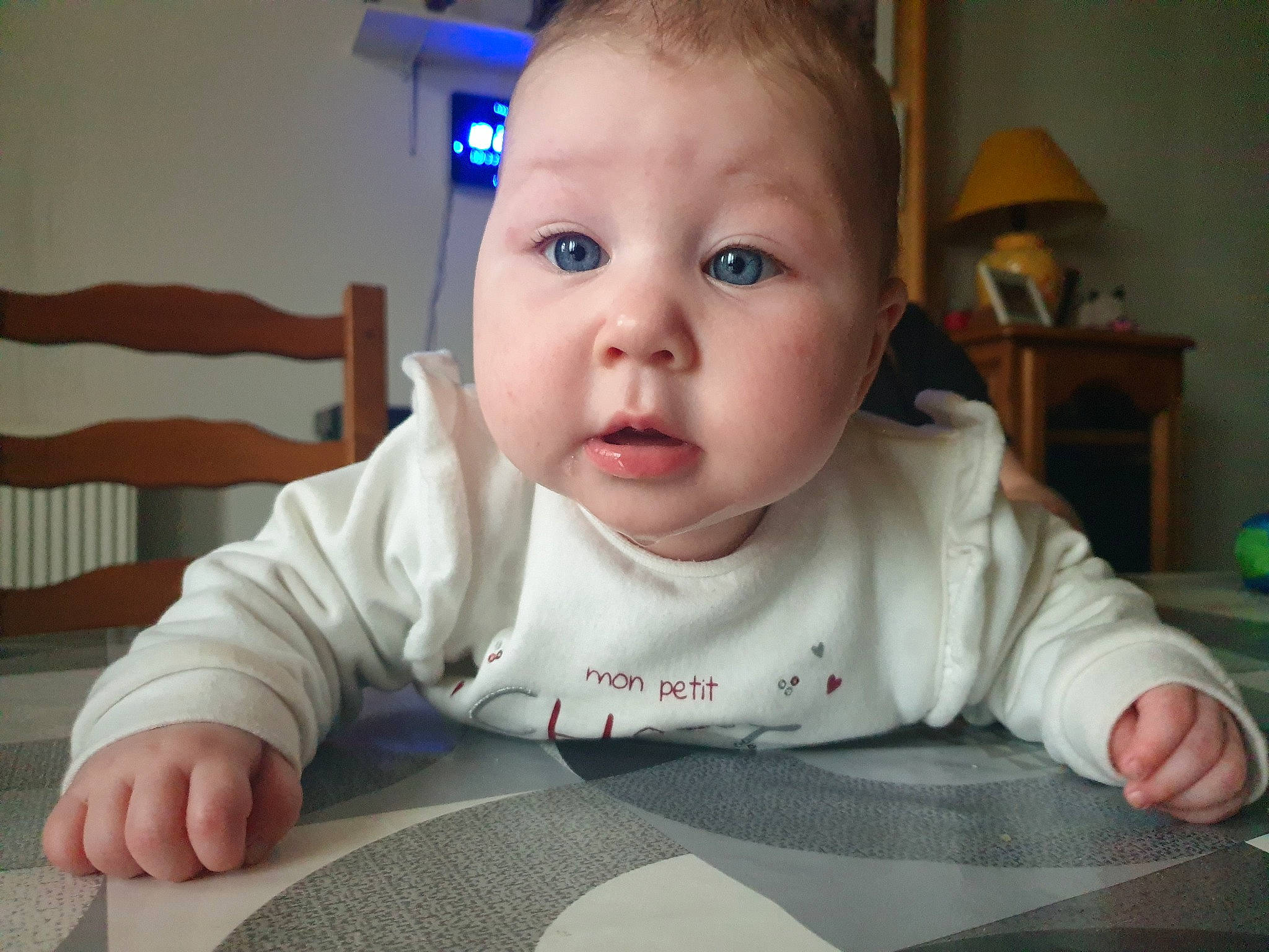 Riley a rejoint le concours — aidez-le/la à gagner de superbes lots ! baby, baby_toddler_clothing, cheek, chin, eye, eyelash, facial_expression, finger, floor, flooring, hair, head, iris, mouth, nose, person, skin, sleeve, toddler, tummy_time