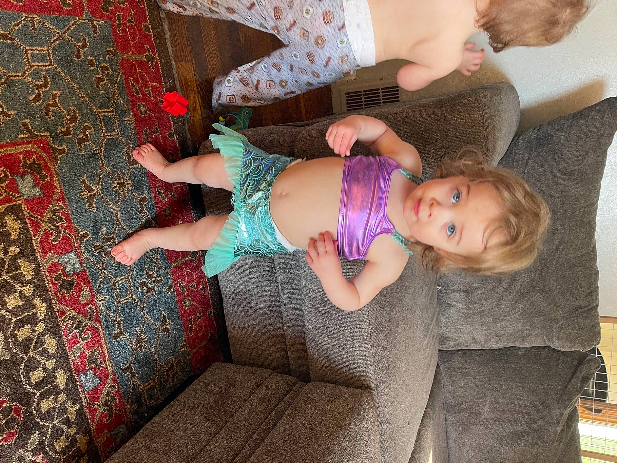 Harper is registered to the contest to win money with this photo: arm, baby, baby_products, baby_toddler_clothing, child, comfort, dress, fun, hand, happy, human_leg, leg, magenta, pattern, person, pink, purple, room, sock, thigh