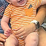 baby, child, smile, happy, infant, onesie, orange_stripes, person, hand, watch, ring, skin, legs, feet, sitting, holding, joy, cute, casual, indoor