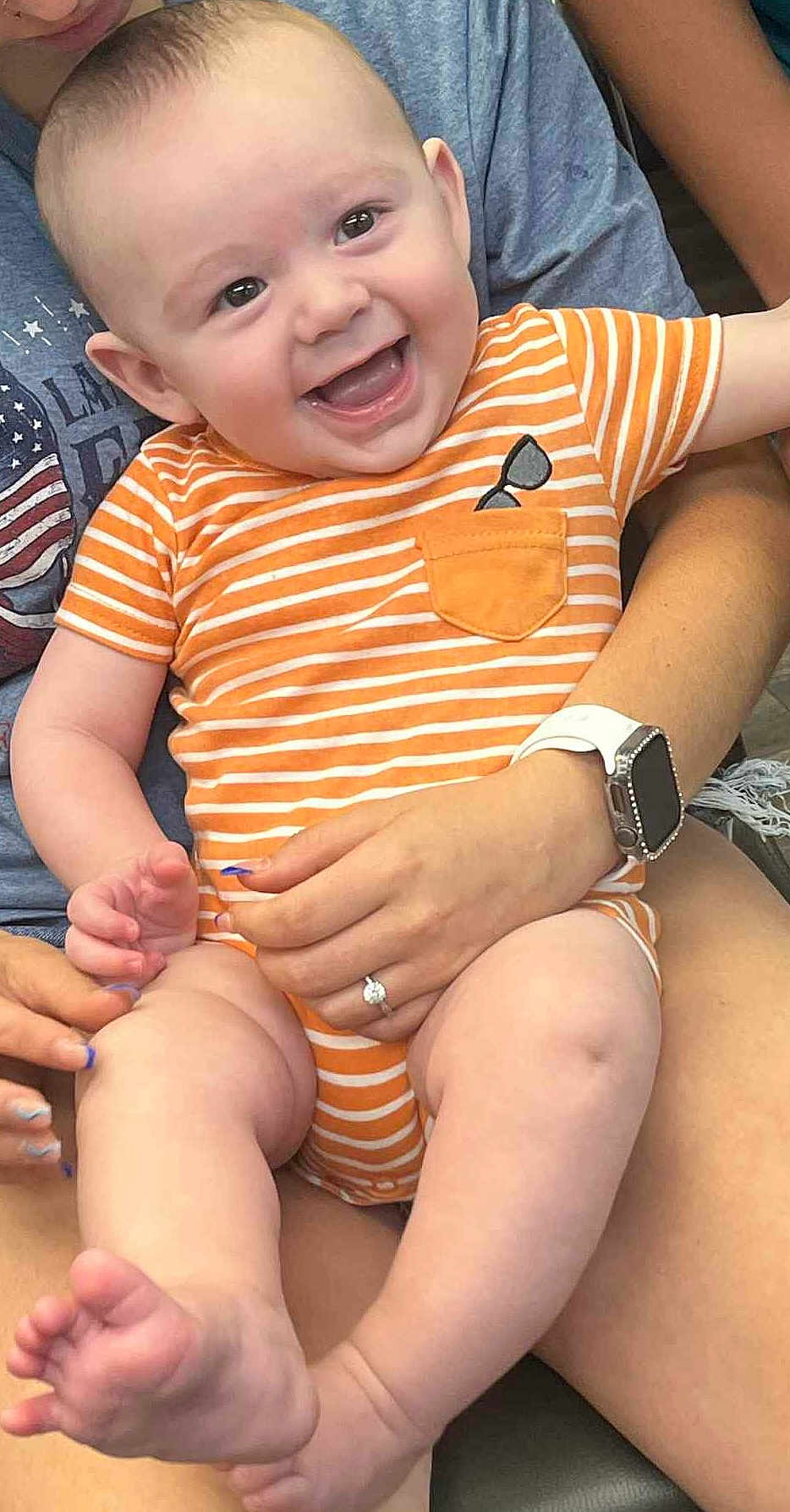 Echo joined the competition — help win amazing prizes! baby, child, smile, happy, infant, onesie, orange_stripes, person, hand, watch, ring, skin, legs, feet, sitting, holding, joy, cute, casual, indoor